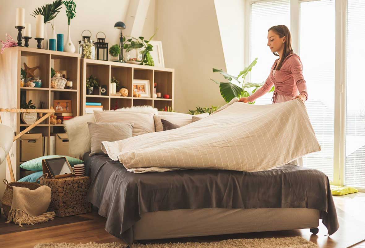 woman deep cleaning her bedroom